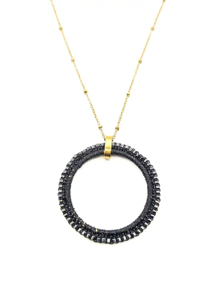 Détail pendentif rond avec broderie de perles noires faite main