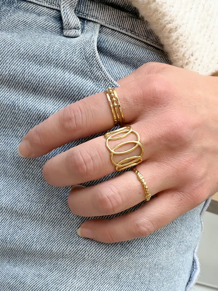 femme avec accumulation de bagues moderne en acier inoxydable doré de qualité