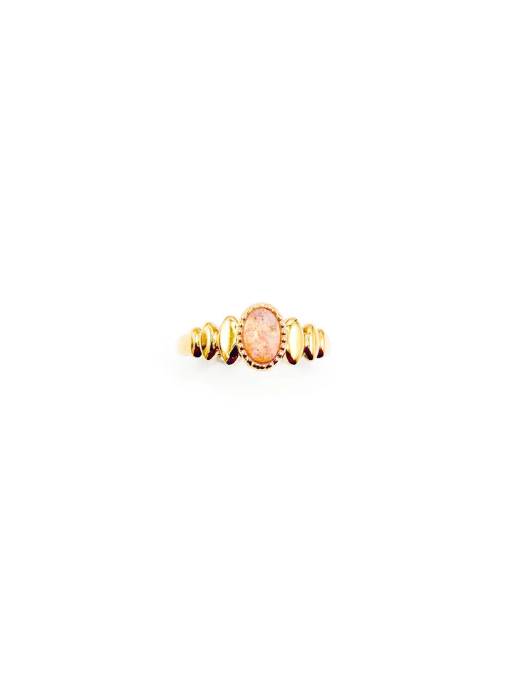 détail bague femme fine dorée en acier inoxydable dorée avec une pierre ovale en quartz rose.