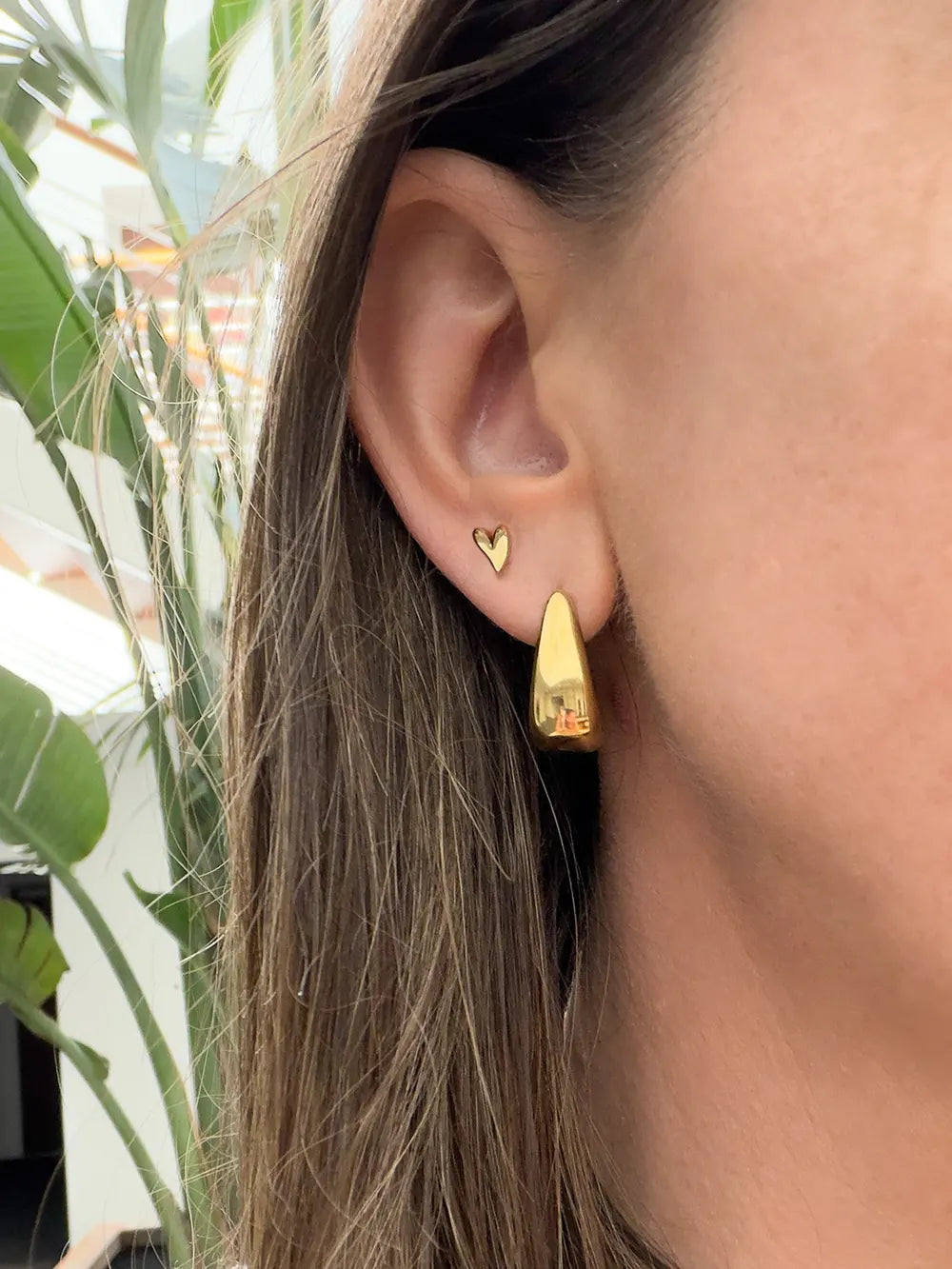 femme portant des boucles d'oreilles Viva Yuza en acier inoxydable doré de qualité.