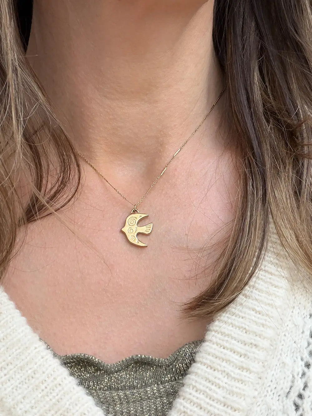 femme portant un collier fin avec un pendentif en forme d'oiseau avec gravure motifs