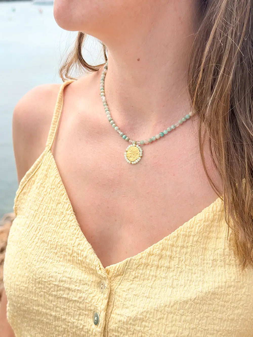 femme portant un collier en pierres naturelles turquoise avec pendentif médaillon martelé
