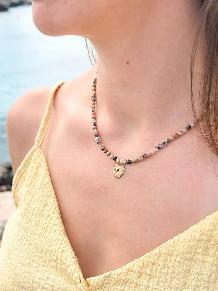 femme portant un collier perles d’opale rose naturelle et pendentif cœur