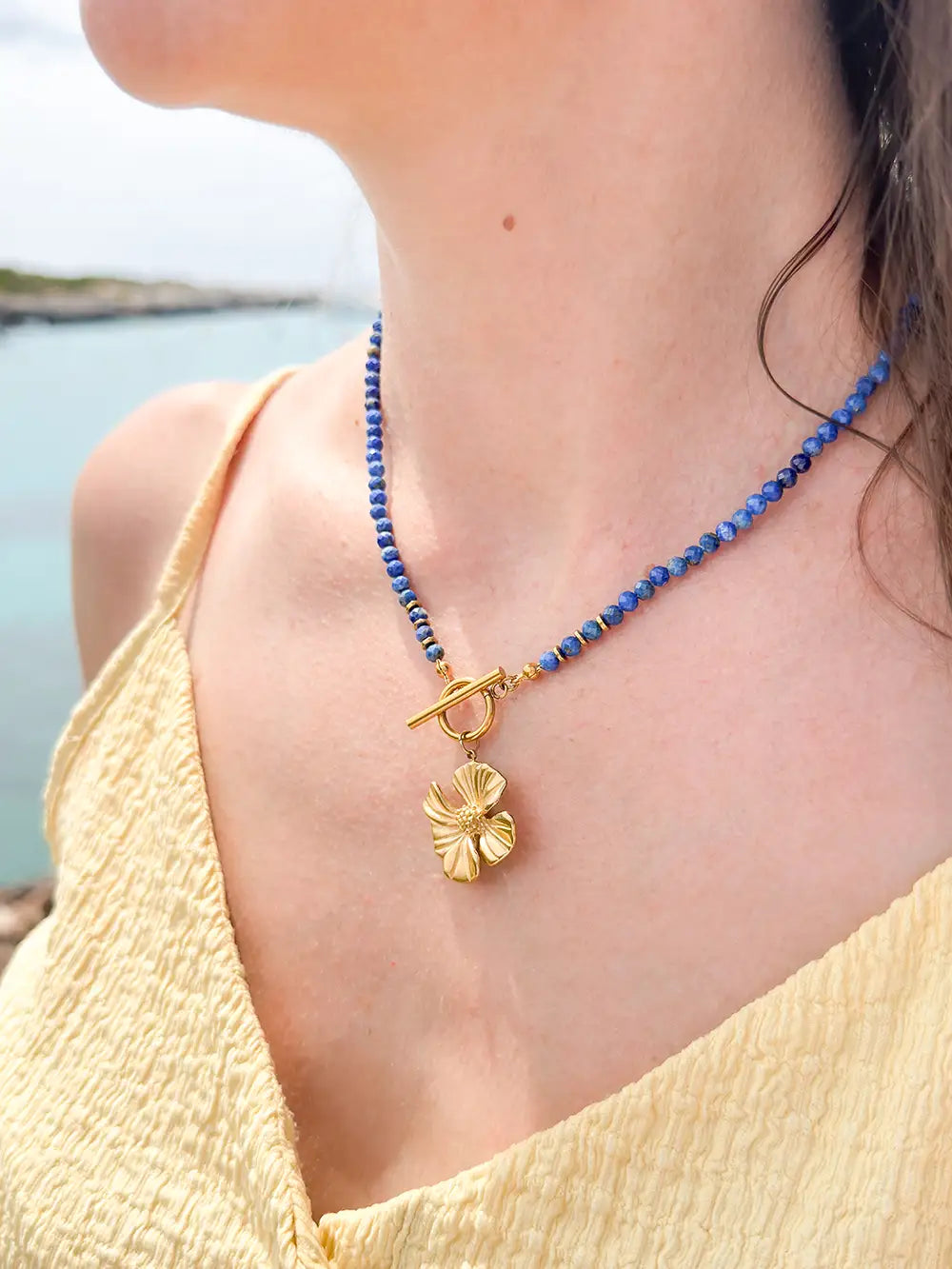 femme portant un collier perles de lapis-lazuli naturel avec fermoir toggle et fleur dorée