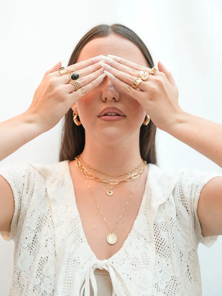 femme portant une collection de bijoux dorées en  accumulation en acier inoxydable de qualité de la marque Viva Yuza